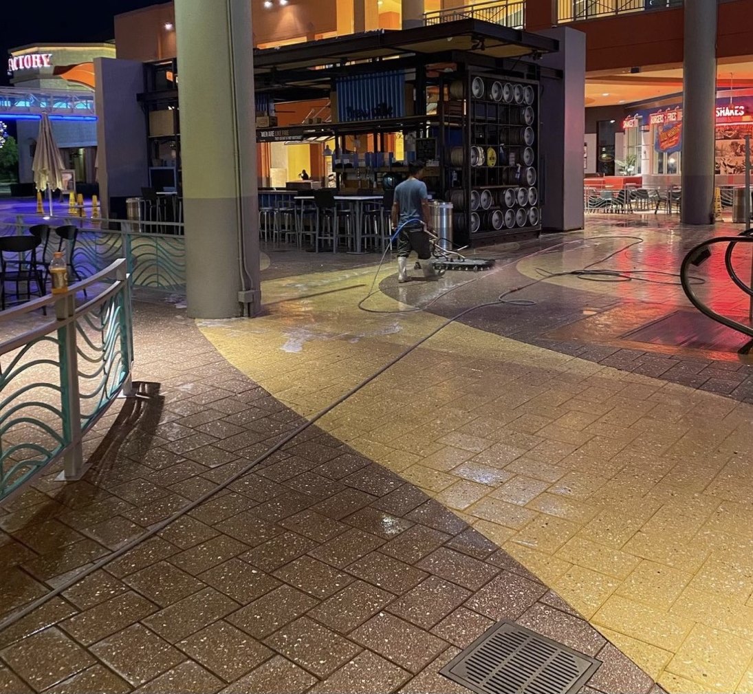 GWS washing a shopping plaza walkway, hose run out and the cleaned strip visible