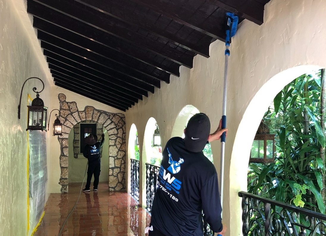 A GWS painter rolling a wall with an extension pole at a Miami property
